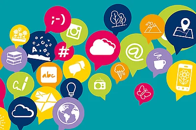 türkiser Hintergrund, bunte runde Sprechblasen in den je ein weißes Icon zu sehen ist. Die Icons sind in Form von zB einem @-Zeichen, einem Smiley-Gesicht, einem Buch, einer Wolke, Buchstaben, einer Weltkugel, etc. 