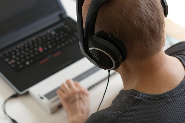 Ein blinder Mann bedient seinen Laptop mit einem ScreenReader (Bildschirm-Leser) und einer Braillezeile (Computerausgabegerät für Bline).