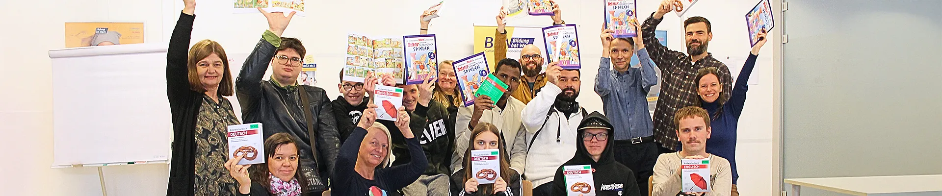 Kurs-Teilnehmende freuen sich gemeinsam mit den Mitarbeitenden von BhW Basisbildung und Zeit Punkt Lesen über ihr Bücher-Geschenk zu Weihnachten 2024.