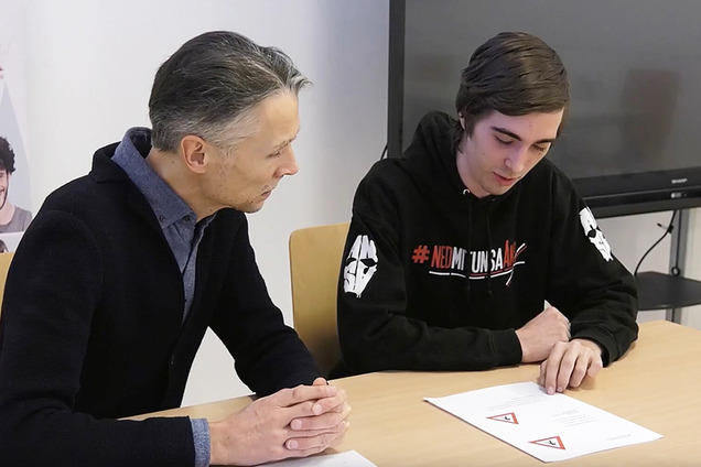 Lernbegleiter Michael und Teilnehmer Matthias sitzen an einem Tisch und schauen auf Lernunterlagen.