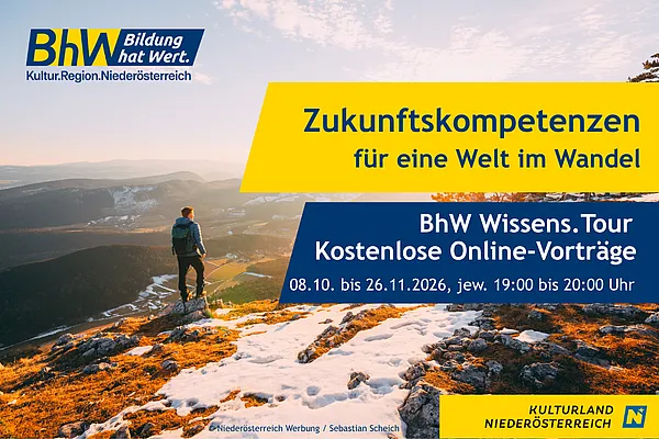 Ein Wanderer steht auf einem schneebedeckten Berg. Die Sonne scheint.