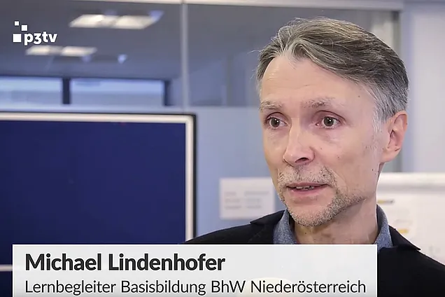 Lernbegleiter der Basisbildung wird interviewt. Es ist eine Schrift zu sehen: Michael Lindenhofer, Lernbegleiter der Basisbildung BhW Niederösterreich
