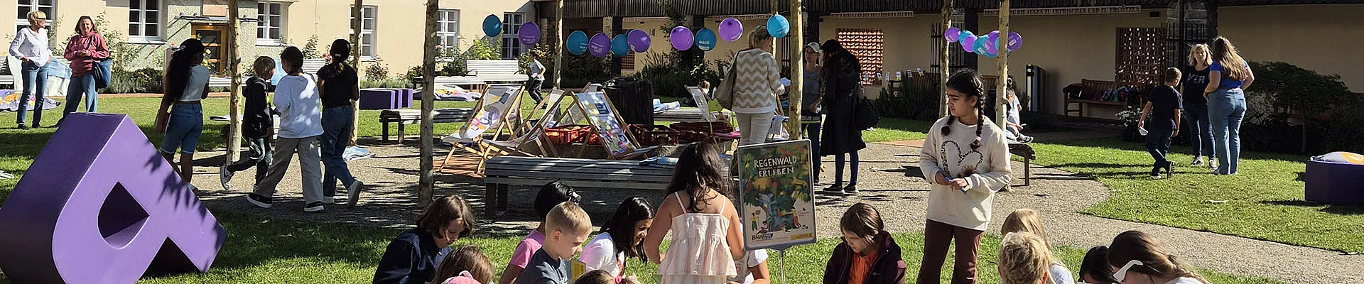 Kinder beim Lesen und Spielen im Alumnatsgarten