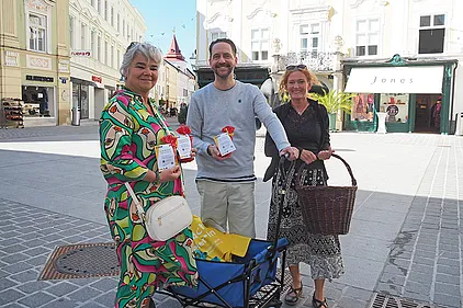 Schauspieler Sven Kaschte und Basisbildungs-Trainerin Brigitte Schönsleben-Thiery verteilen Buchstabennudeln-Sackerl. Daran befestigt: QR-Codes, die zu Lesetipps für die Familie auf der BhW-Website führen.
