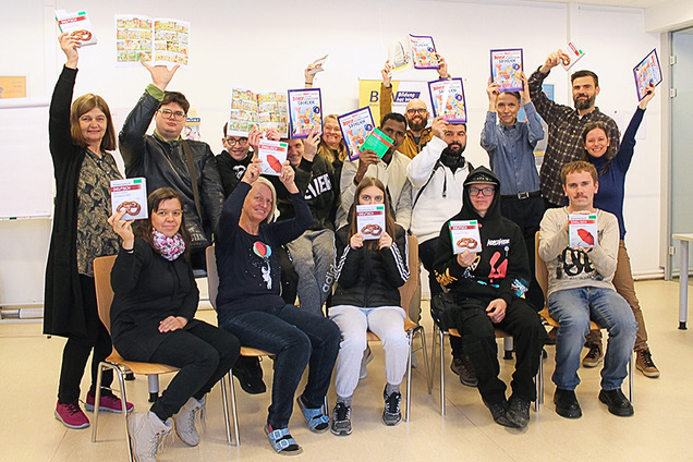 Kurs-Teilnehmende freuen sich gemeinsam mit den Mitarbeitenden von BhW Basisbildung und Zeit Punkt Lesen über ihr Bücher-Geschenk zu Weihnachten 2024.