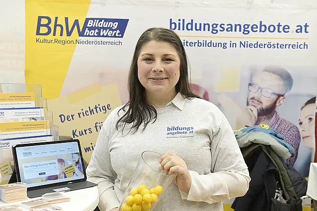 Stefanie Halbwachs (bildungsangebote.at) vorm Stand des BhW auf dem Tag der Weiterbildung in der AK NÖ.