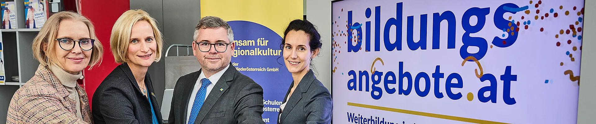Das Team der Steuerungsgruppe und LR Schleritzko halten die Hände symbolisch über einem Buzzer, der die neue Bildungsdatenbank einläutet.