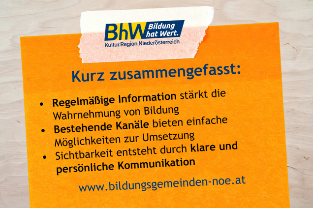 Orange Haftnotiz auf einem Holztisch. Darauf Tipps für Bildungsgemeinderätinnen und -räte.