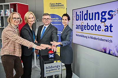 Das Team der Steuerungsgruppe und LR Schleritzko halten die Hände symbolisch über einem Buzzer, der die neue Bildungsdatenbank einläutet.