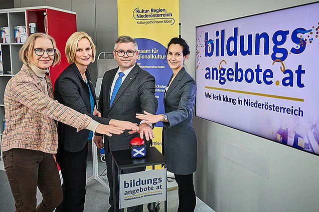 Das Team der Steuerungsgruppe und LR Schleritzko halten die Hände symbolisch über einem Buzzer, der die neue Bildungsdatenbank einläutet.