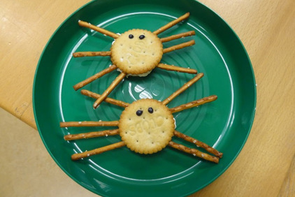 Ein Teller mit Halloween-Spider-Snack (Kekse gefüllt mit Frischkäse und Soletti als Spinnenbeine)