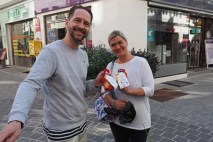 Schauspieler Sven Kaschte verteilt Buchstabennudeln-Sackerl. Daran befestigt: QR-Codes, die zu Lesetipps für die Familie auf der BhW-Website führen.