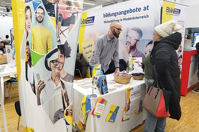 Tobias Hauzeneder berät gerade einen Kunden am Stand des BhW am Tag der Weiterbildung in der AK NÖ