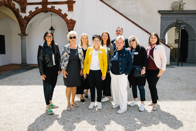 Bildungsgemeinderätinnen und Kulturverantwortliche stehen als Gruppe im Hof der Schallaburg. Alle sind bunt angezogen.
