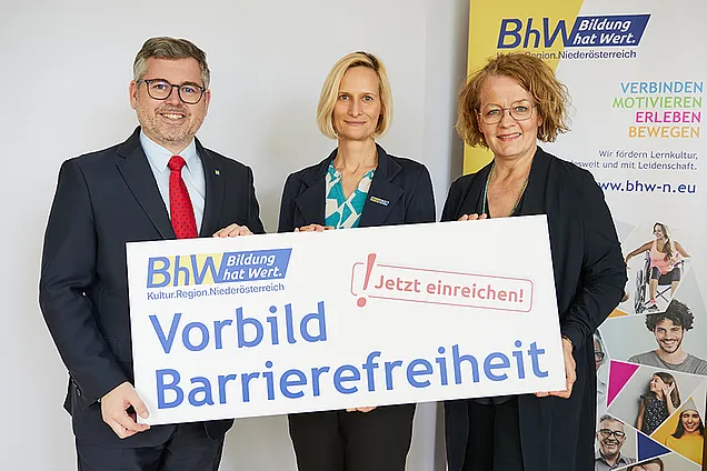 Gruppenbild, Landesrat Ludwig Schleritzko, BhW Geschäftsführerin Therese Reinel und Landesrätin Christiane Teschl-Hofmeister stehen vor einem BhW_Rollup und halten ein Schild hoch, auf dem steht: Vorbild Barrierefreiheit - Jetzt einreichen!