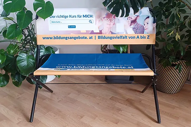 eine klappbares Bankerl mit Werbung für die Website Bildungsangebote.at vom BhW NÖ