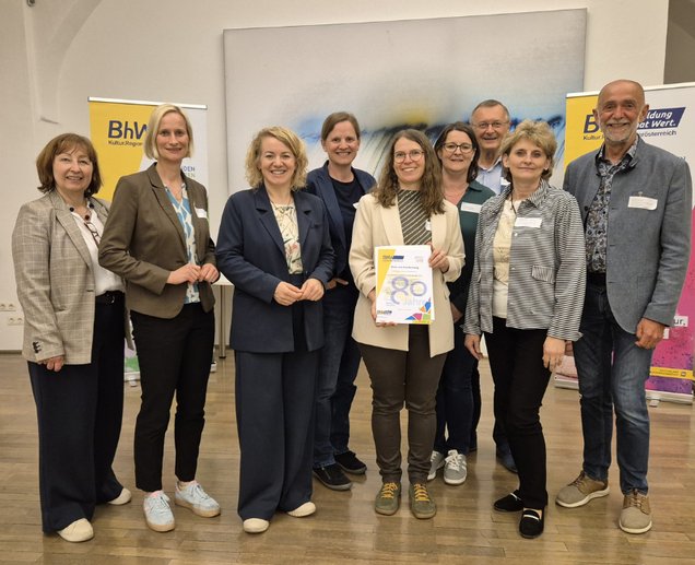 Ein Gruppenbild mit einer Person welche eine "Danke für 80 Jahre" Urkunde bekommen hat.