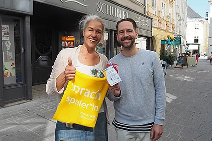 Schauspieler Sven Kaschte verteilt Buchstabennudeln-Sackerl. Daran befestigt: QR-Codes, die zu Lesetipps für die Familie auf der BhW-Website führen.