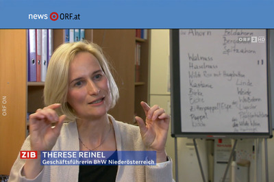 BhW Geschäftsführerin Therese Reinel sitzt in einem Schulungsraum vor einem Bücherregal und Flipchart und wird interviewt.