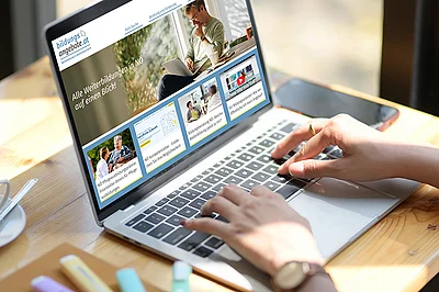 aufgeklappter Laptop mit der Bildungsdatenbank auf dem Bildschirm. Zwei weibliche Hände tippen auf der Tastatur.
