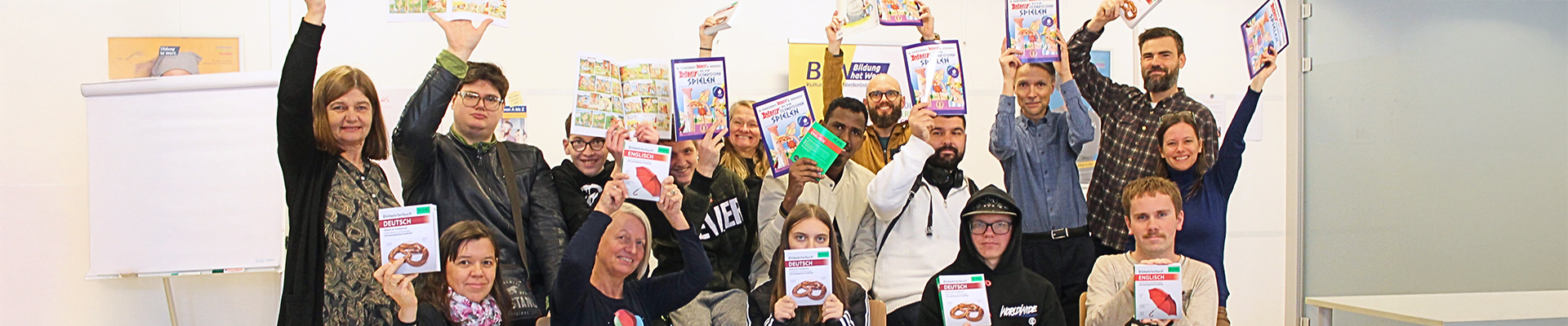 Kurs-Teilnehmende freuen sich gemeinsam mit den Mitarbeitenden von BhW Basisbildung und Zeit Punkt Lesen über ihr Bücher-Geschenk zu Weihnachten 2024.