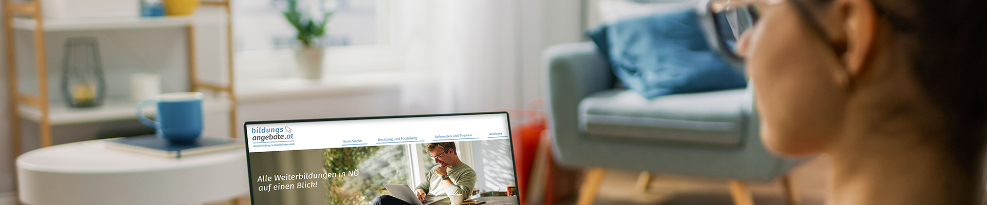 Eine Frau sitzt auf der Couch, hat einen Laptop am Schoss und schaut in die Bildungsdatenbank NÖ.