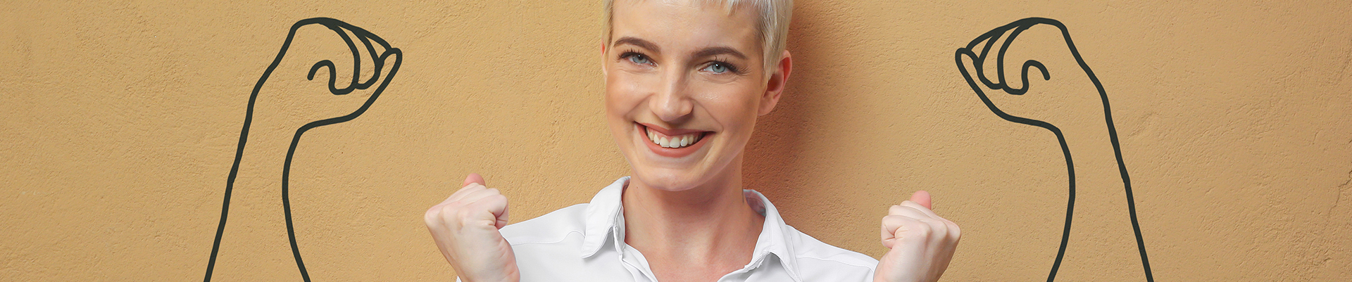 Eine Frau steht vor einer brauen Wand auf der zwei angespannte Arme gezeichnet sind. Diese sollen Stärke vermitteln.